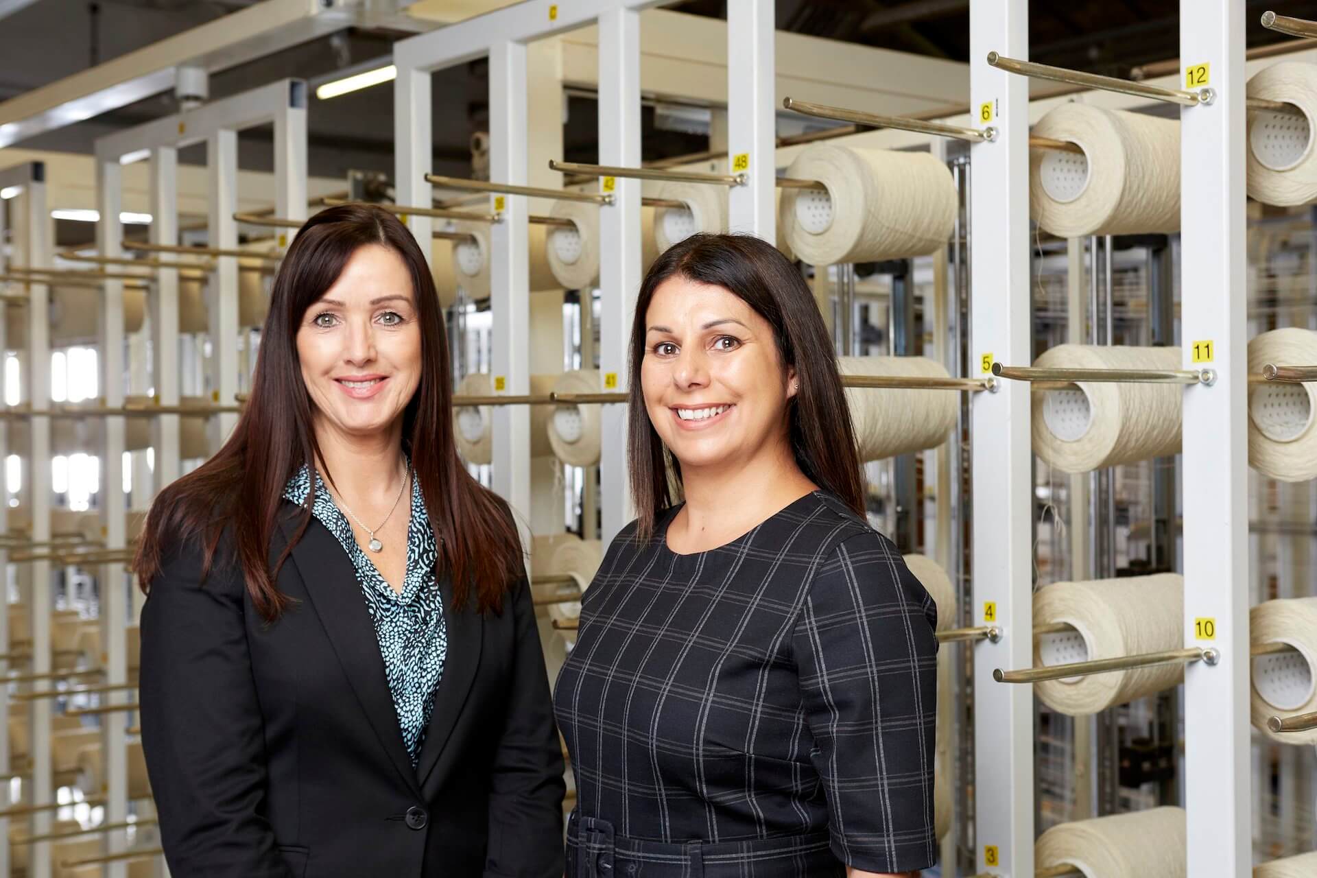 Two women smiling after finding out that Red Diamond partners with heritage textiles firm